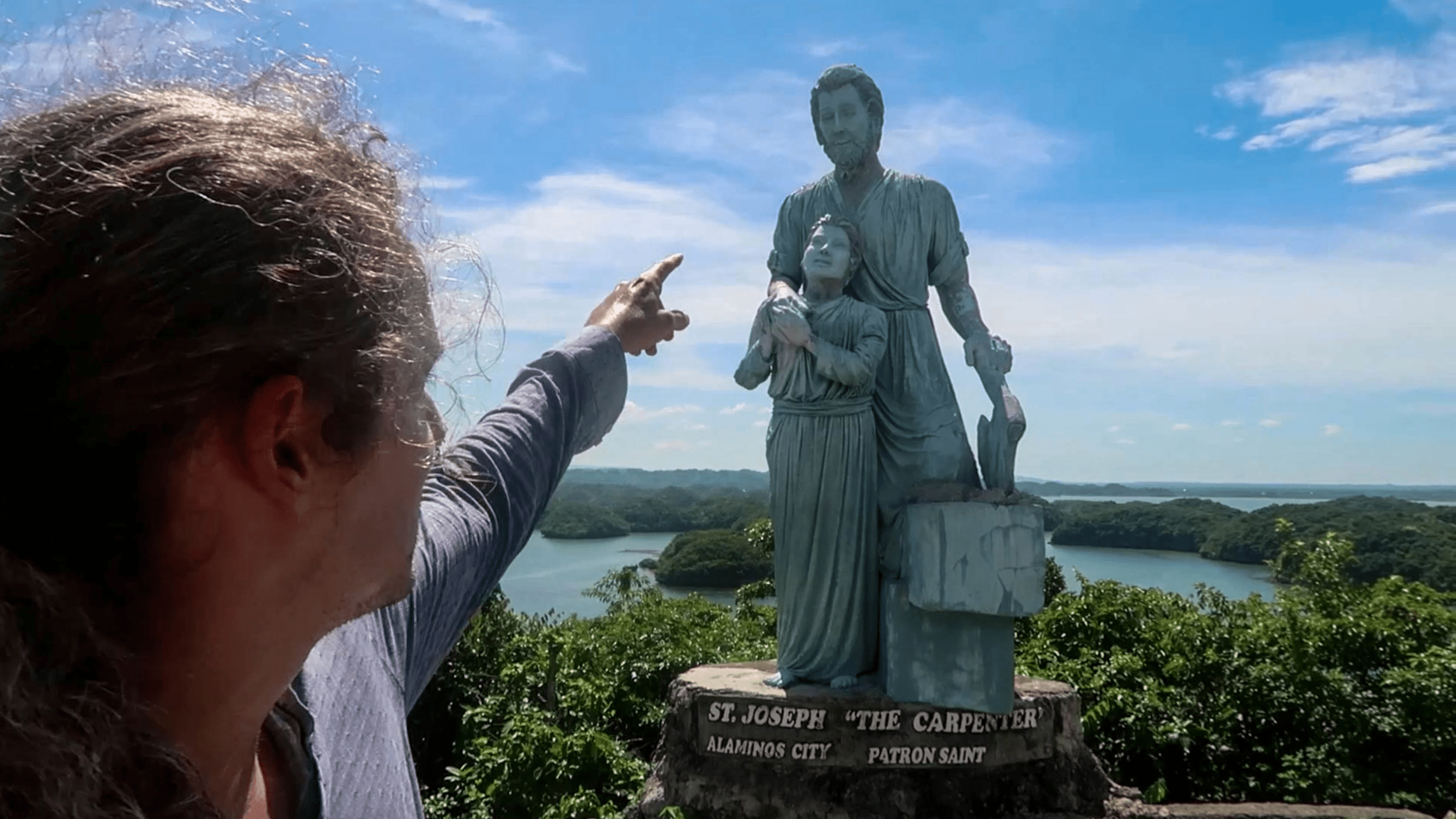 lenny through paradise pointing at statue at hundred islands pangasinan philippines